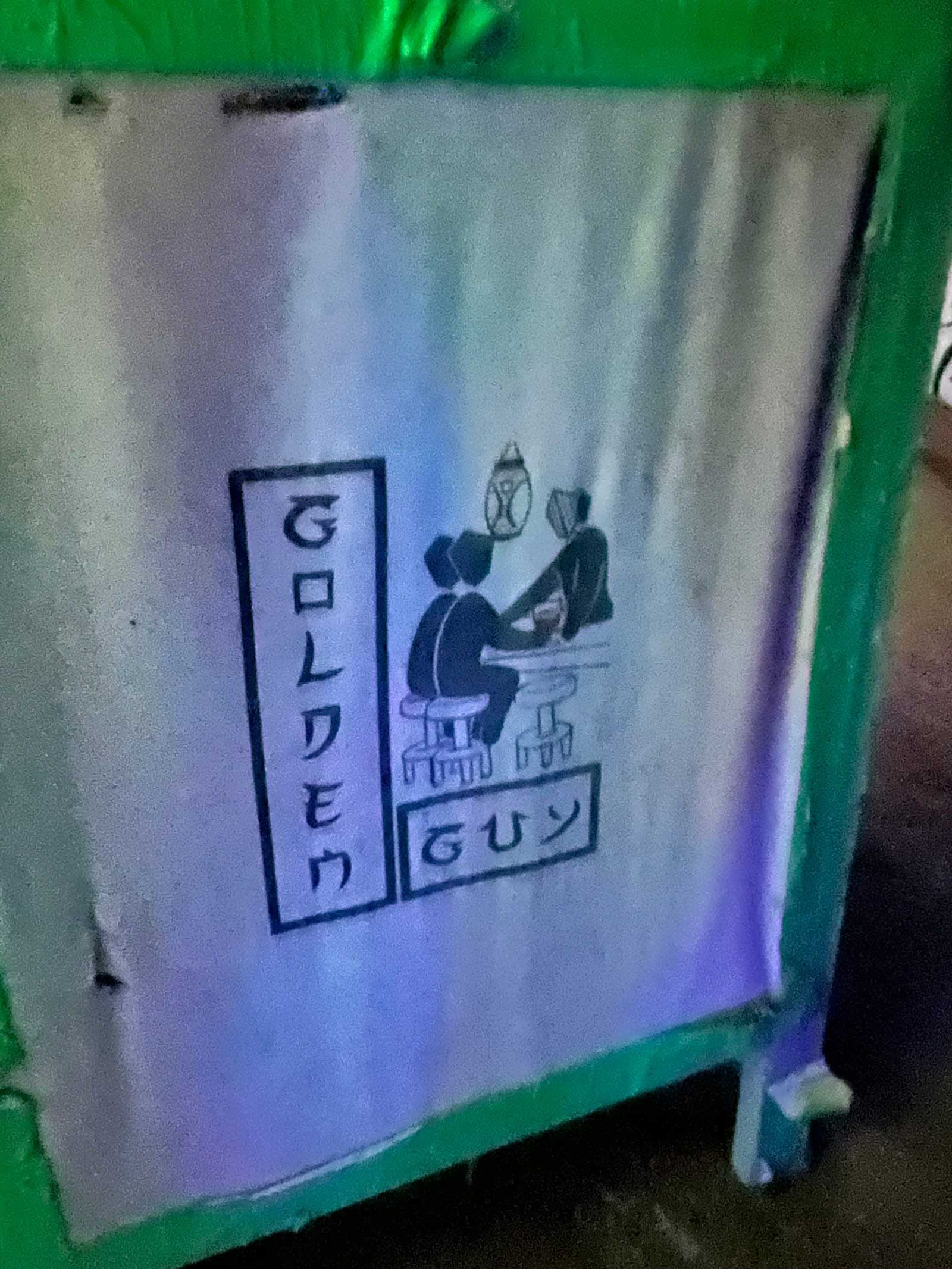 A street sign at Burning Man marking Golden Guy, a camp modeled after Tokyo’s Golden Gai district of tiny bars.