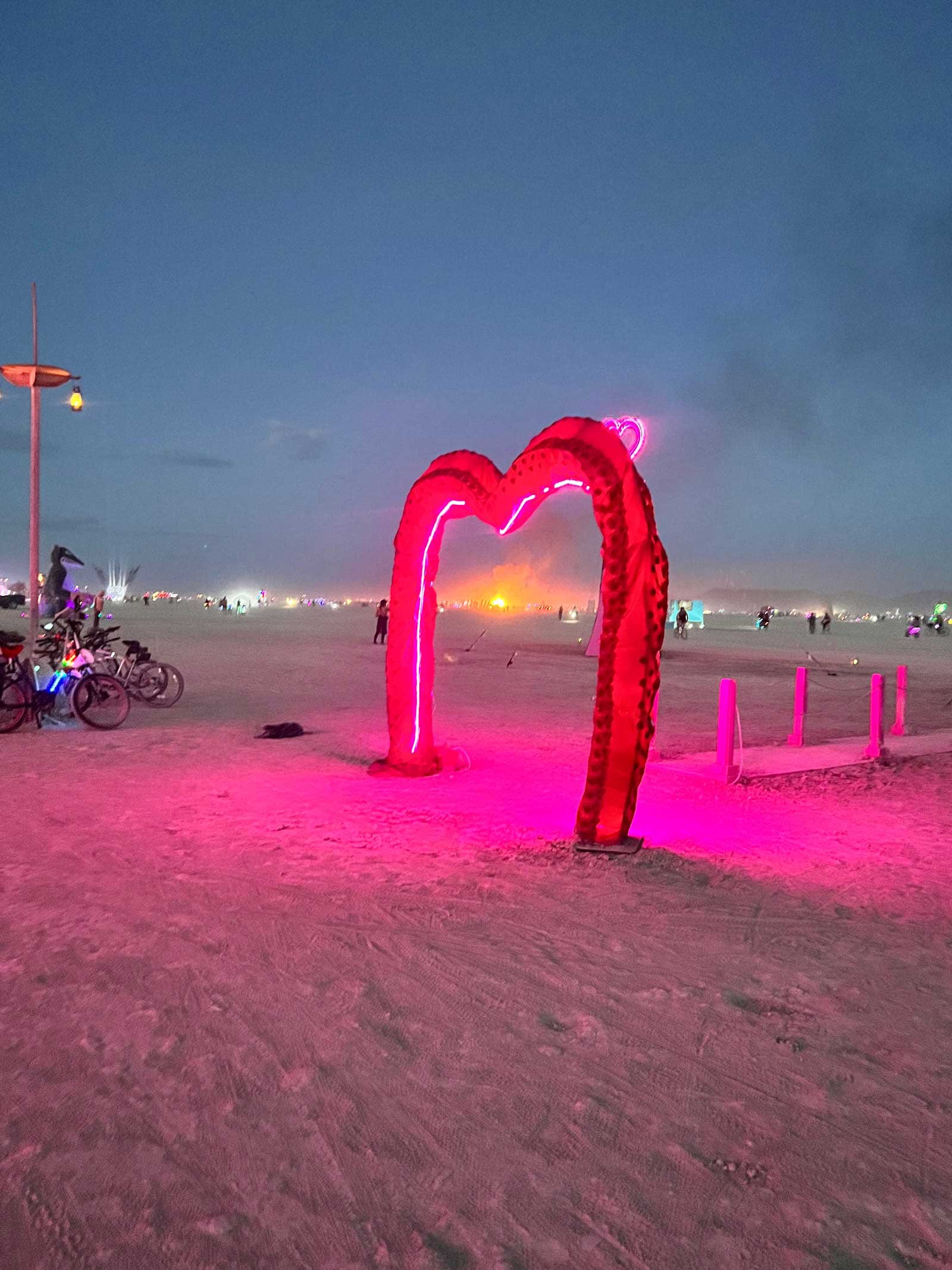 Pink Heart Camp at Burning Man with rows of pink couches where Burners rest, hydrate, and watch the city pass by.