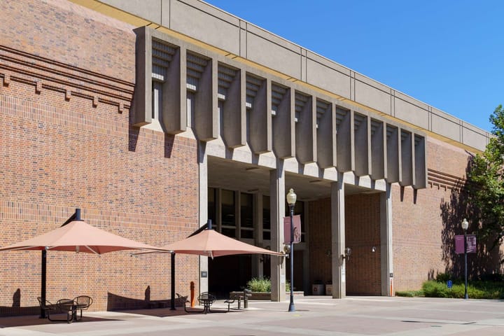 Exterior of the Meriam Library at CSU Chico, a brick academic building with deep-set windows and shaded entryways. The gateway to a formative space of discovery