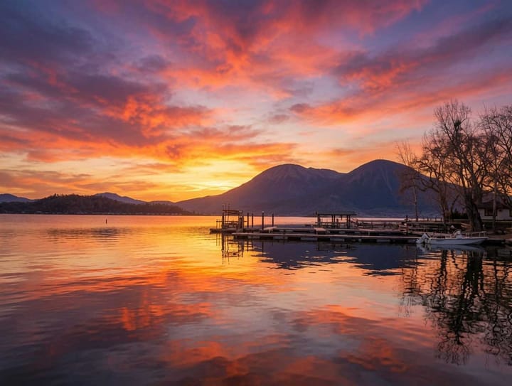 Mount Konocti glowing gold and red at sunset over Clear Lake, with docks silhouetted in the foreground.